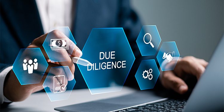 Due diligence icons superimposed over an executive working on a computer.