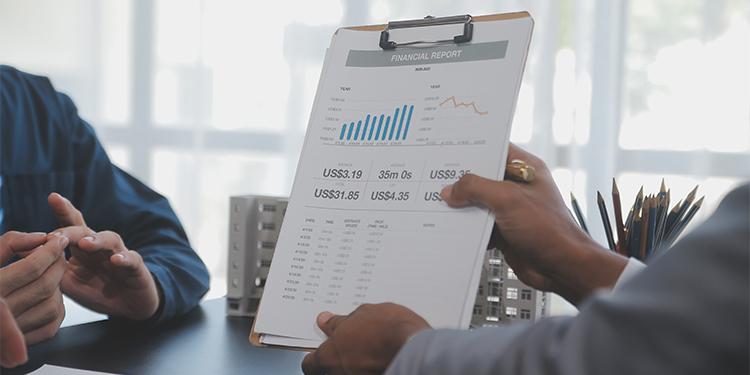 Business owner receiving offer for the business, with financials on clipboard. 