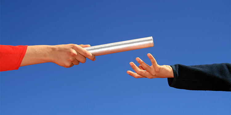 Business owners passing the baton to new owner in business transaction.